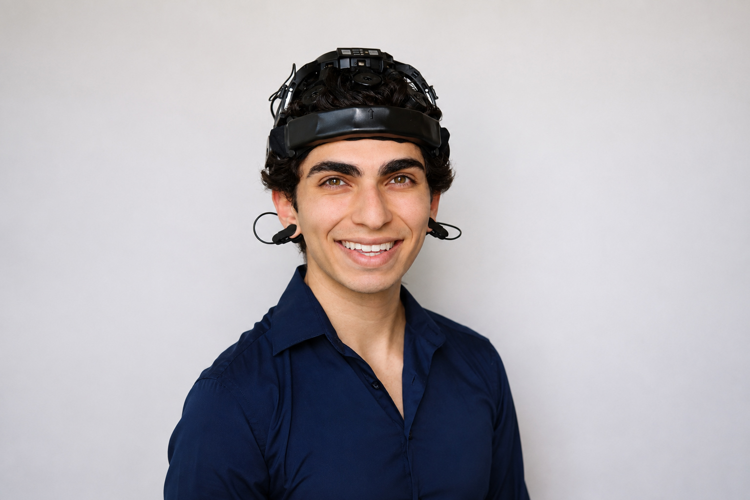 Noah Bakayou smiling while wearing an EEG headset.